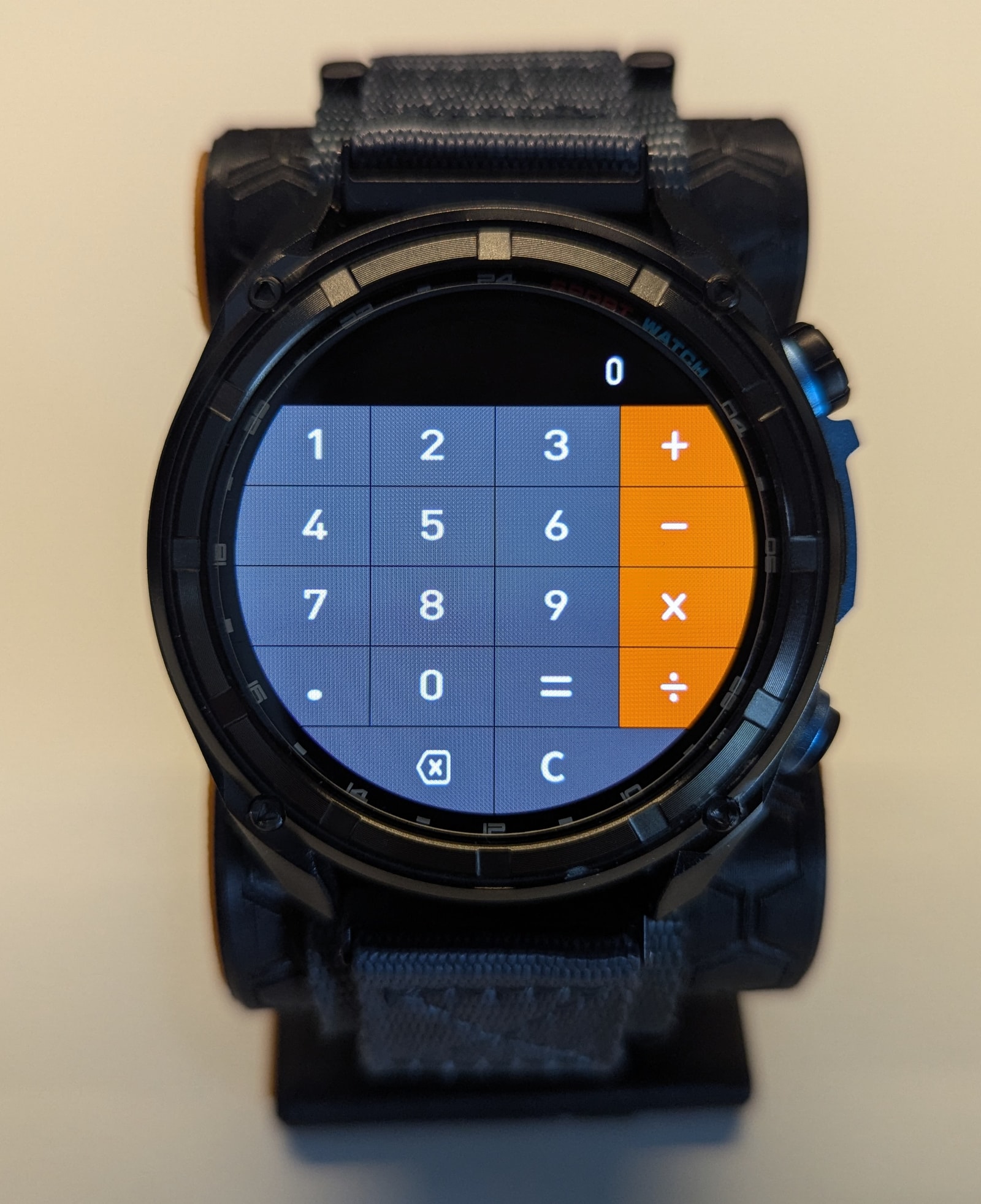 The KKTICK Tank T5 calculator app open on the watch, showing a large grid-based keypad that fits the round display cleanly